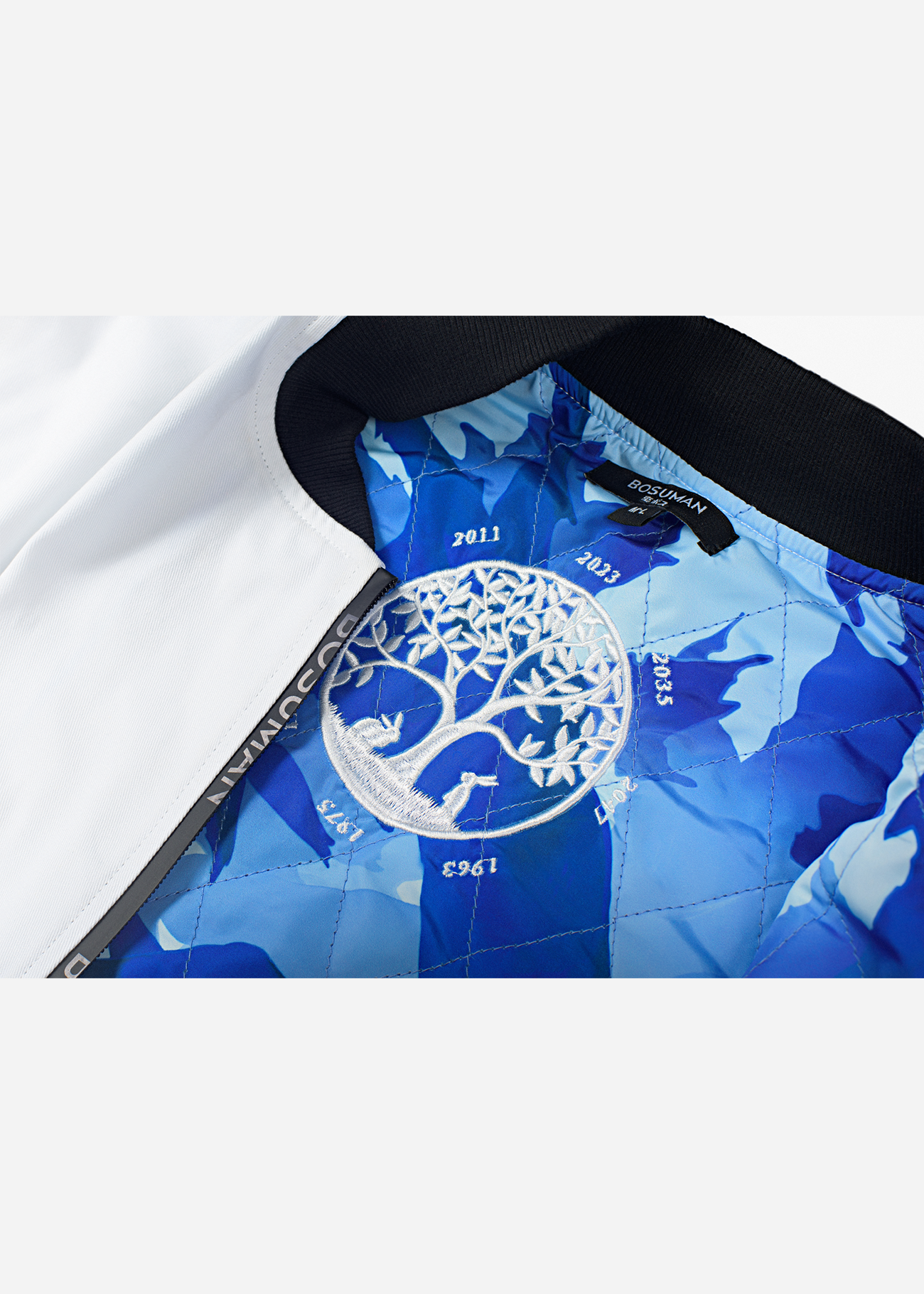 Close up of the inside embroidery of the zodiac bomber jacket, showing a white tree